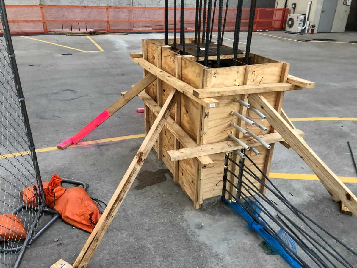 Braced timber column formwork with protruding rebar.