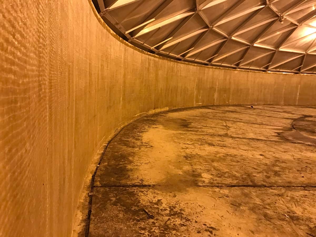 Sweeping curved interior tank wall covered with composite fabric beneath a dome.