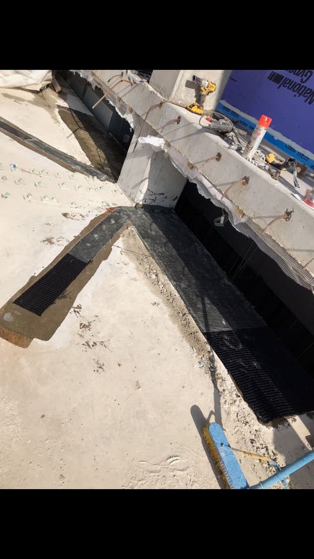 Trench cut in a slab top with dark composite strip laid along its sides.