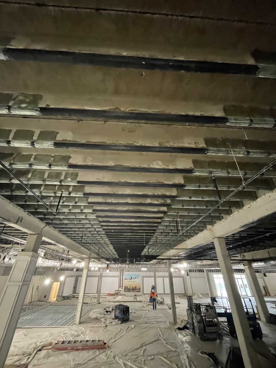 Concrete rib ceiling with carbon fiber bands above an open floor.