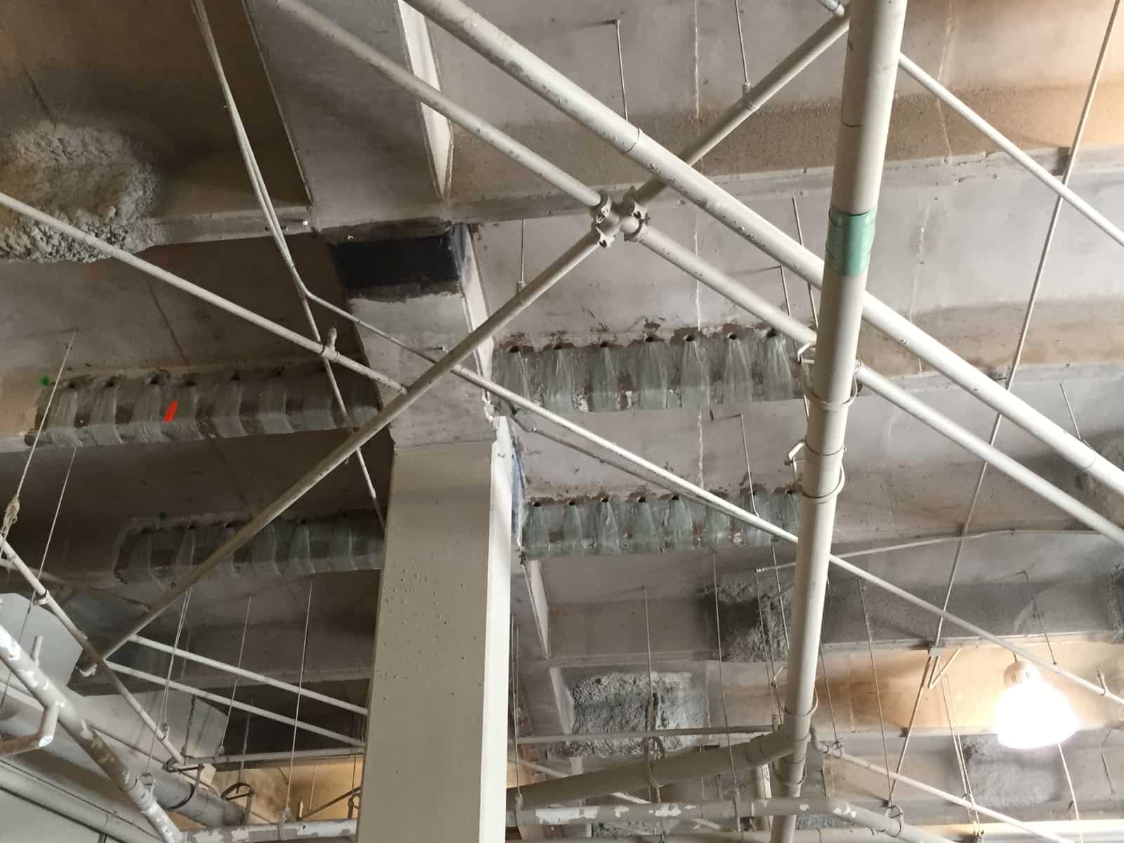Beams with composite wraps, fan anchors and a black carbon fiber patch at a column.