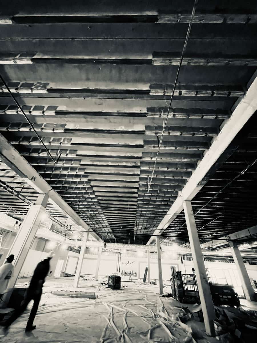 Black-and-white view of a joist ceiling with carbon fiber bands in an open space.