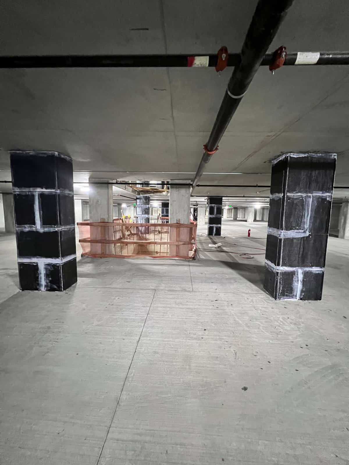 Two carbon fiber wrapped columns on a garage level.