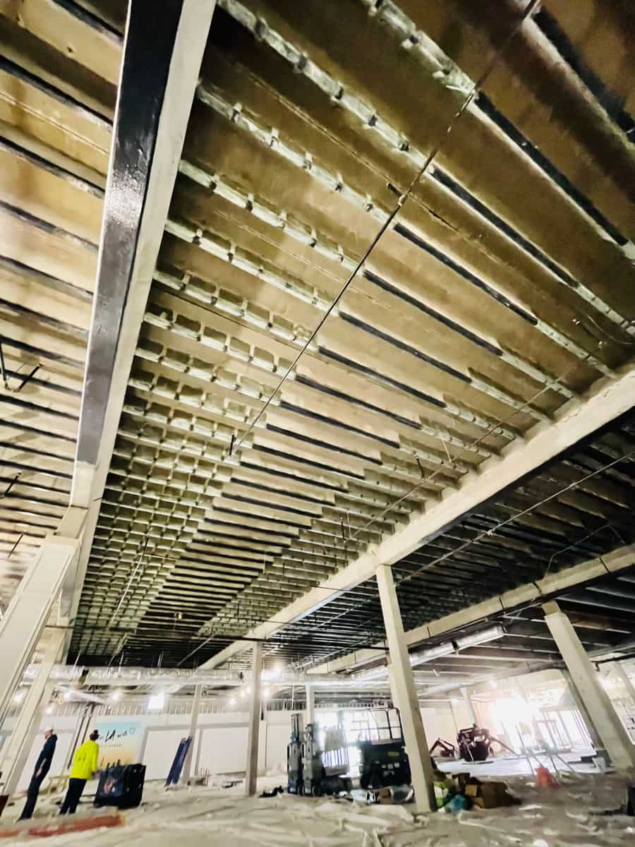 Pan-joist ceiling with carbon fiber bands over an open floor with columns.