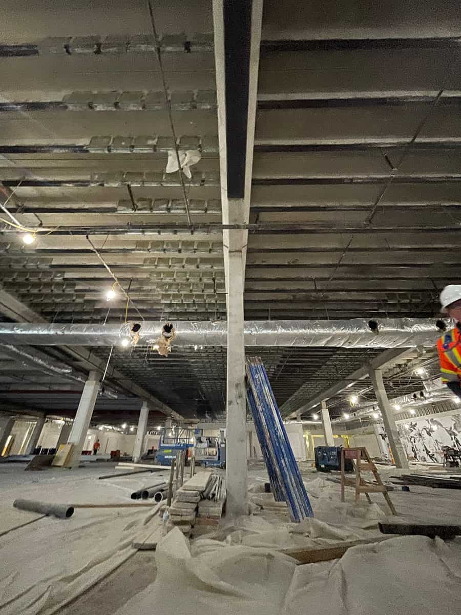 Joist ceiling with carbon fiber strips over a column and open floor.