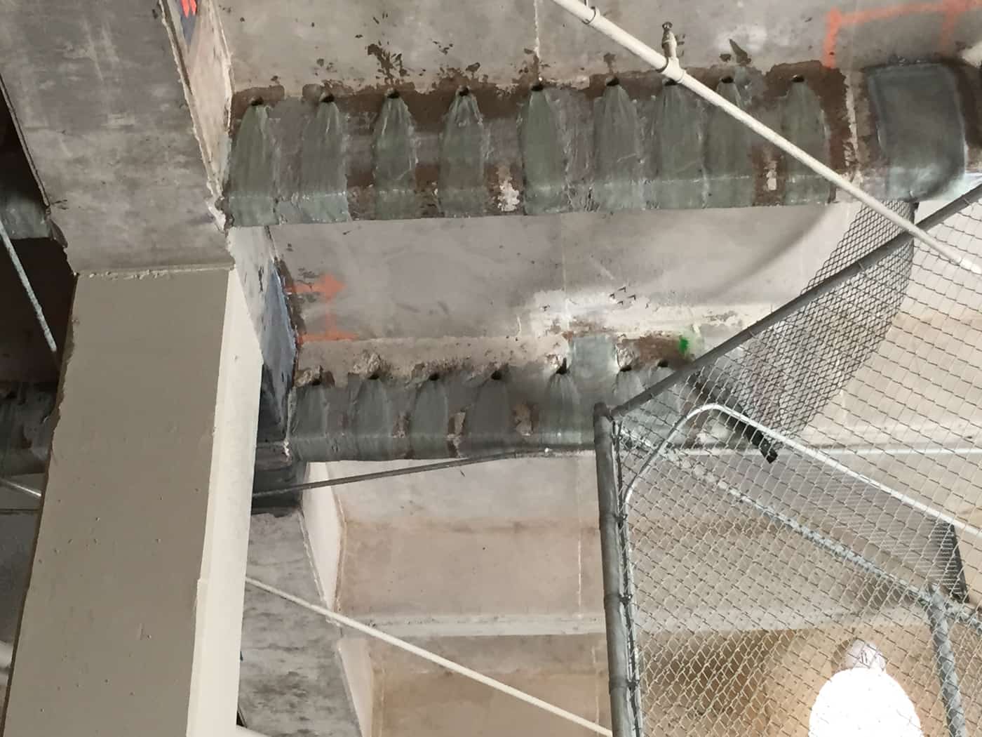 Concrete beam with a composite wrap and a row of fan anchors at a column.