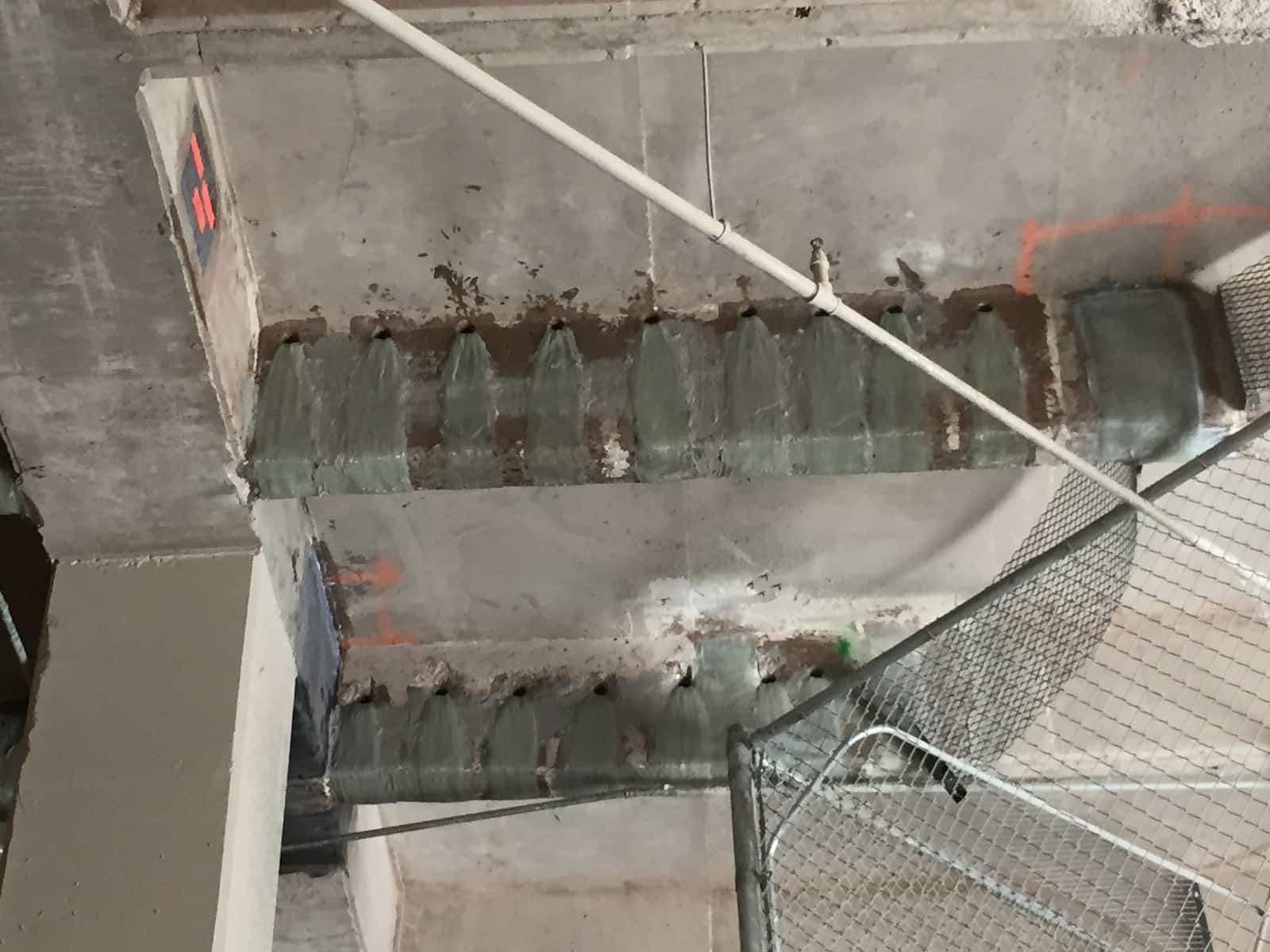 Concrete beams with glass fiber wraps and fan-type fiber anchors along the top edge.
