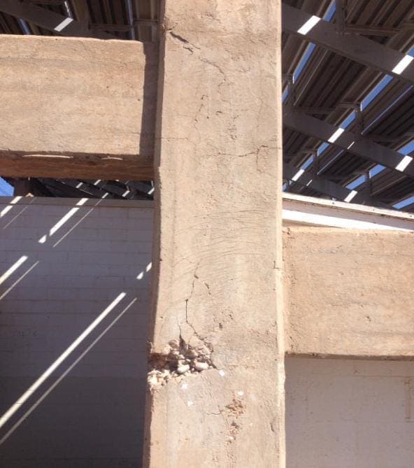 Underside of stadium stands showing concrete beams and supports.