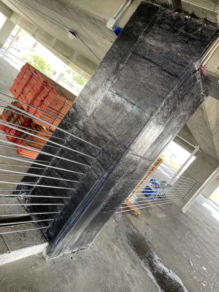Carbon fiber wrapped garage column next to a cable guardrail.