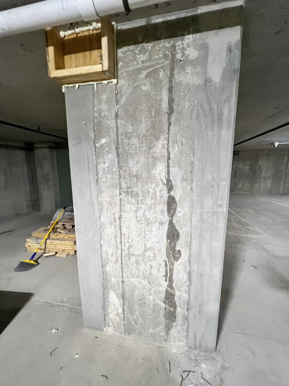 Concrete column with a vertical patched crack line.