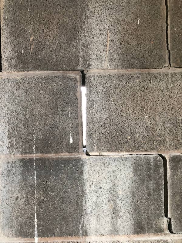 Close-up of a concrete masonry wall with a cracked, open mortar joint.
